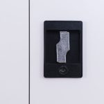 Close-up of black recessed handle key lock mechanism on steel door.